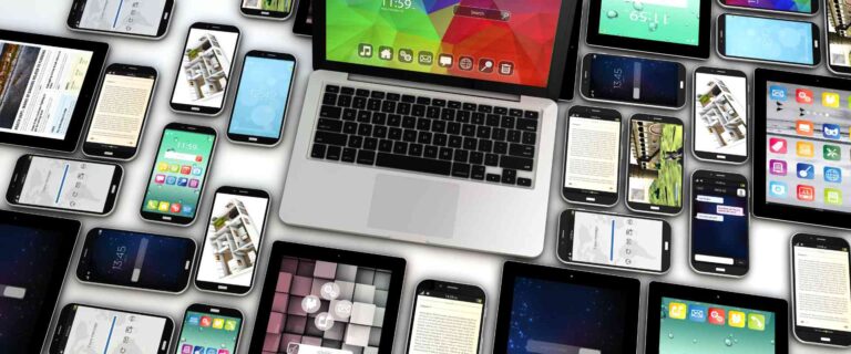 Különböző digitális eszközök képernyői egy laptop körül, a többcsatornás digitális ügyfélélmény érintkezési pontjait szemléltetve